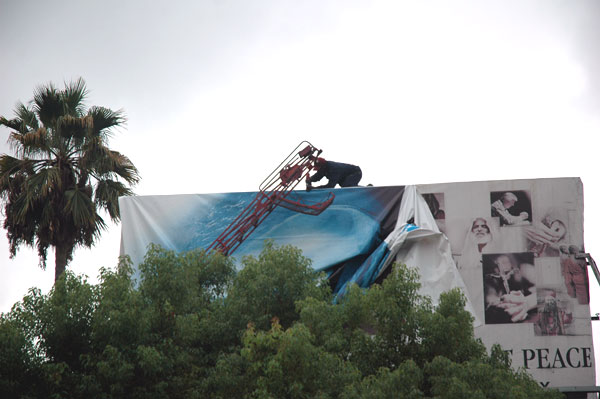 Man working on changing over a billboard, Sunset Boulevard at Formosa, Hollywood