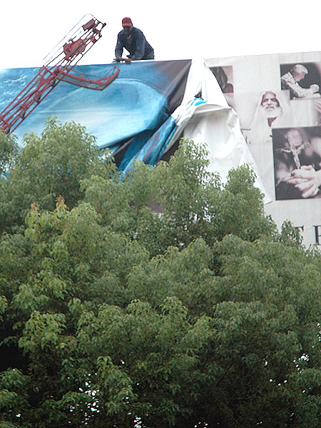 Man working on changing over a billboard, Sunset Boulevard at Formosa, Hollywood